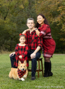 Family portrait with one child and one dog outside in the fall.