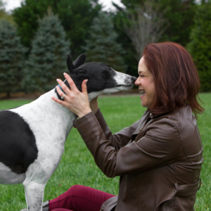 Greyhound kissing her happy owner outside in Loudoun County, VA.