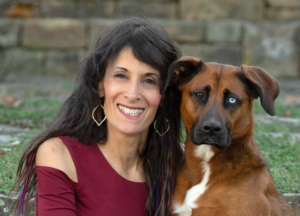 Pet photographer Ellen Zangla with one of her dogs, Lola, sitting outside at their home.