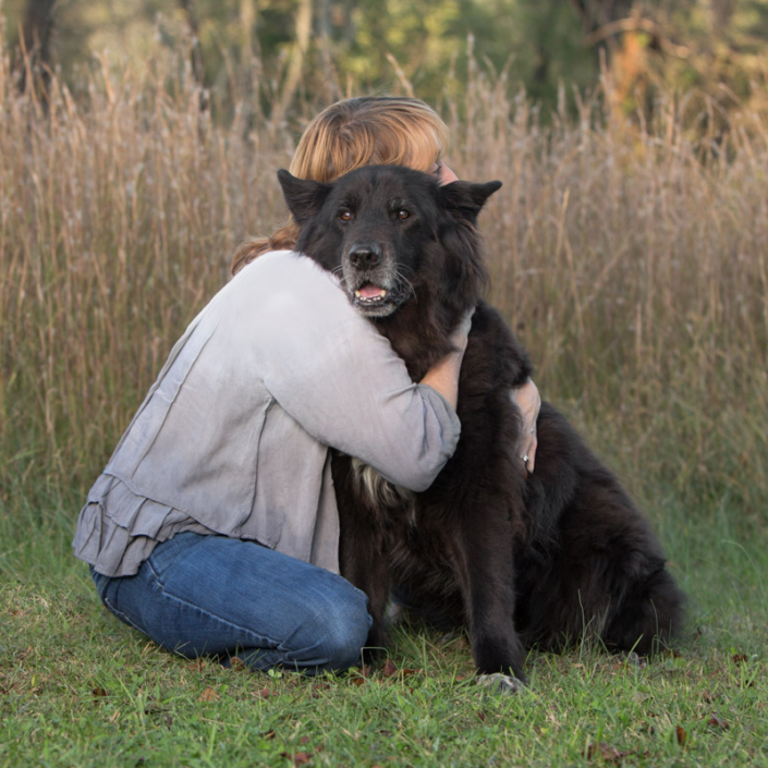 Photo of a woman hugging her older dog outside in Northern VA.