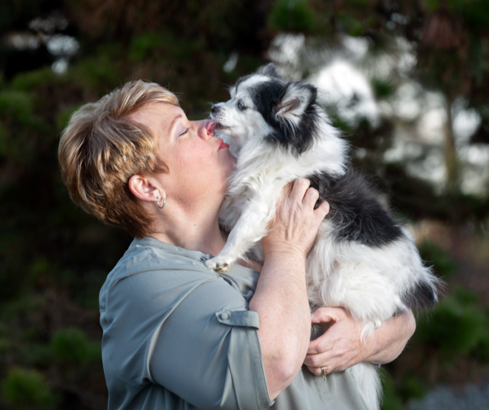 Dog kissing owner on the face outdoors in Loudoun County, VA.