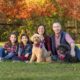Family photo with two adults, two kids, and two dogs outside in the fall in Loudoun County.