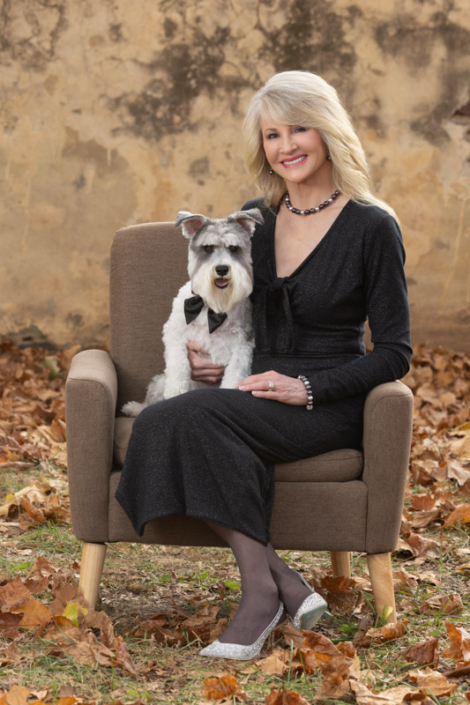 Woman sitting in a chair with her miniature Schnauzer outside in Leesburg, VA.