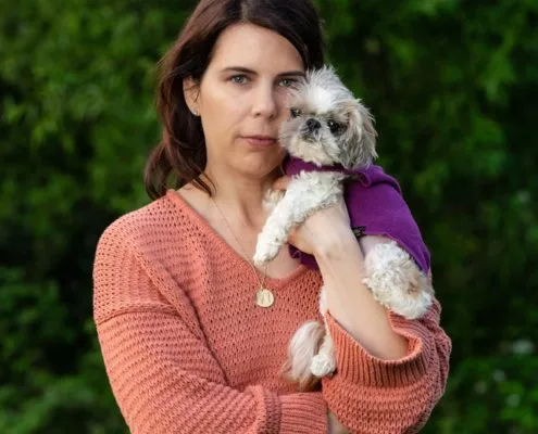 Woman Outside Holding Dog | Northern Virginia Woman outside holding small dog close to her face in Loudoun County, VA.