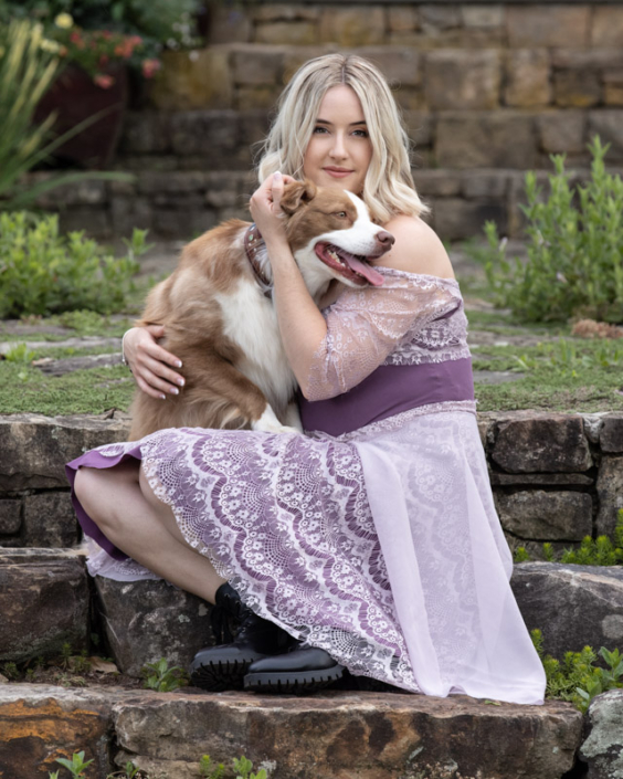 Woman hugging dog while sitting on steps outside in Loudoun County.