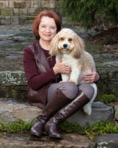 Woman sitting with her dog on her lap outdoors in Northern Virginia.