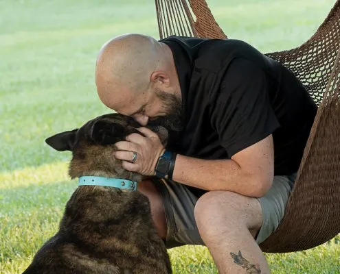 Man Hugging Dog Outside | Loudoun County, VA Man hugging his dog outdoors in Loudoun County